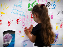 Powiększ obraz: dziewczynka odciska dłonie na białym plakacie