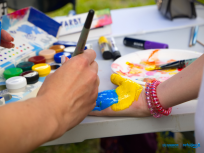 Powiększ obraz: malowanie niebiesko-żóltych barw na dłoni dziecka