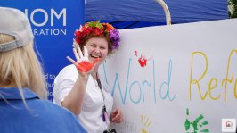 Powiększ obraz: uśmiechnięta kobieta, na dłoni barwy Polski